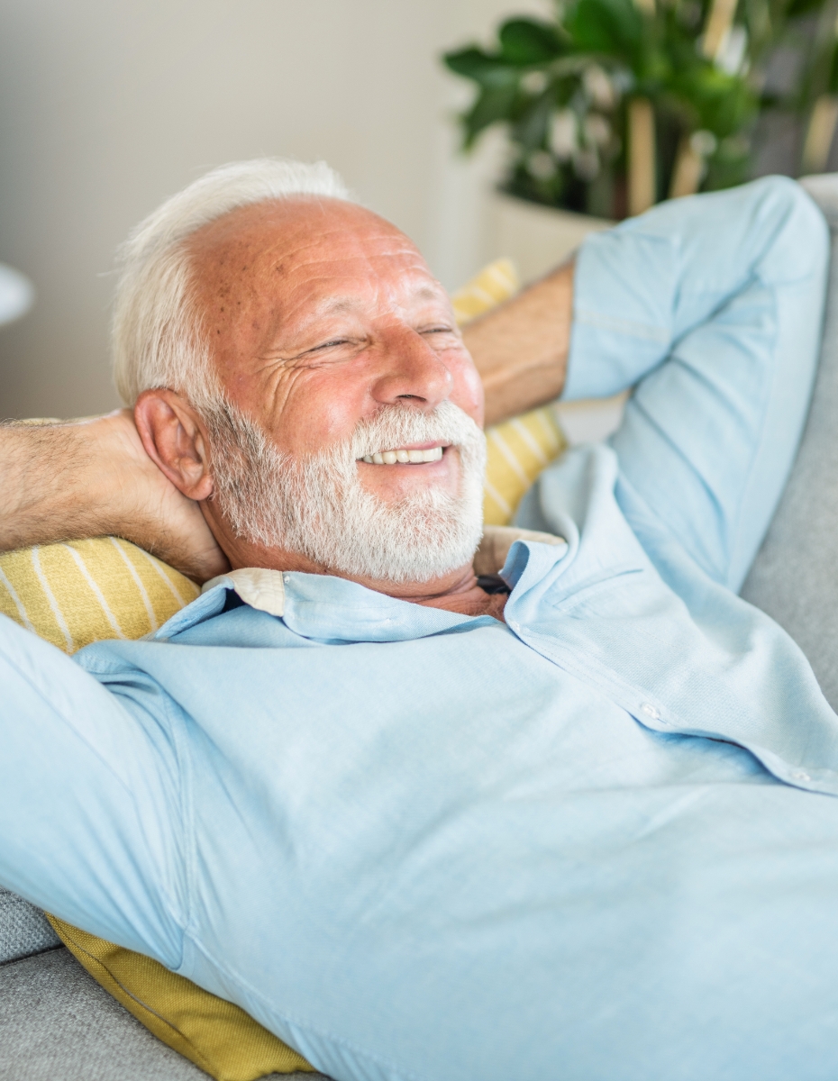 Älterer Mann liegt auf dem Sofa. 